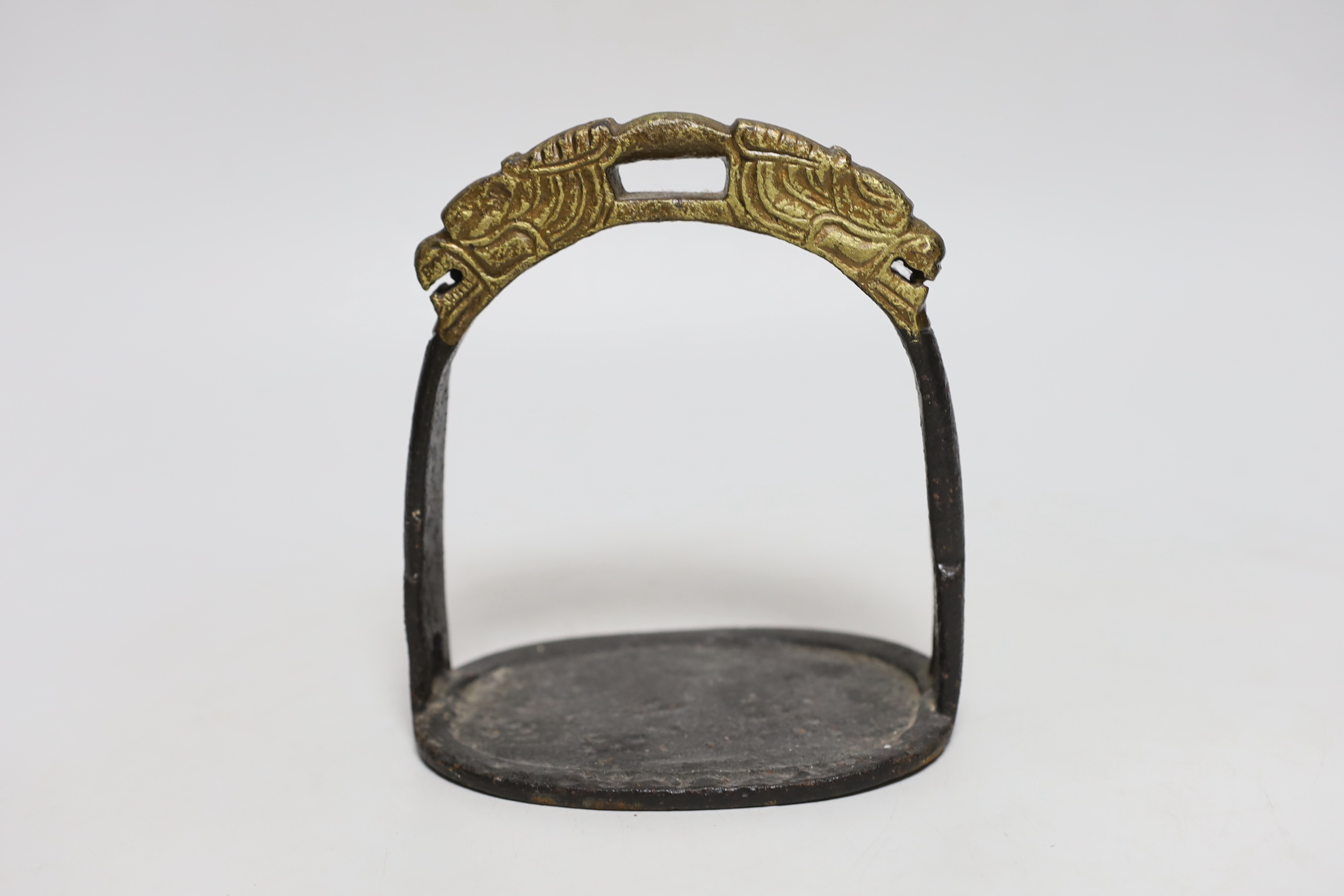 A Chinese cast iron stirrup, with dragon decoration, 16cm high